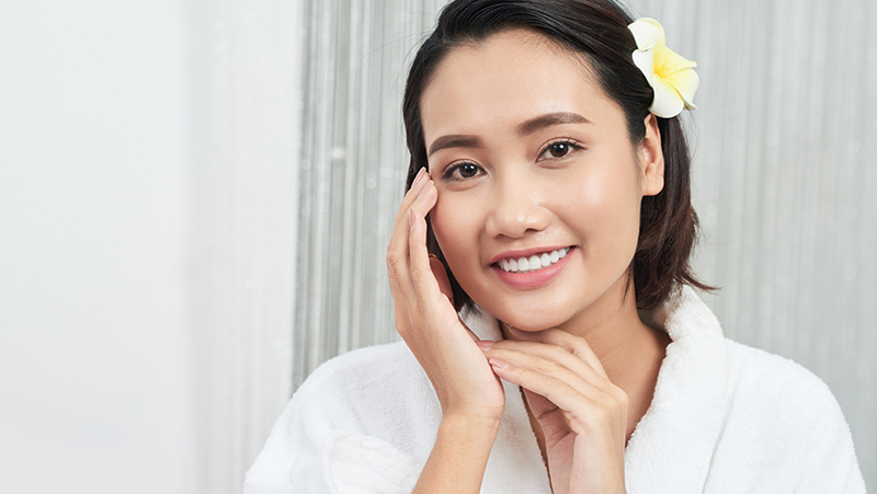 Toronto_Cosmetic_Clinic_Cosmetic_Surgery lady touching her face smiling